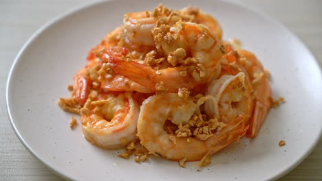 fried shrimps or prawns with garlic on white plate - seafood style