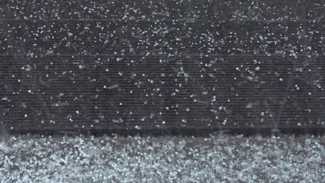 unexpected hail storm in a stormy spring day. close up of large ice pieces falling from the sky on the porch