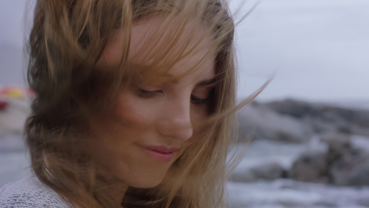 가까운 초상화 아름다운 여성 미소를 짓고 해변을 즐기며 해변에서 휴식을 취하고 바람이 불고 머리카락을  ⁇ 고 평화롭고 무모한 생활 방식을 탐험하고 있습니다.