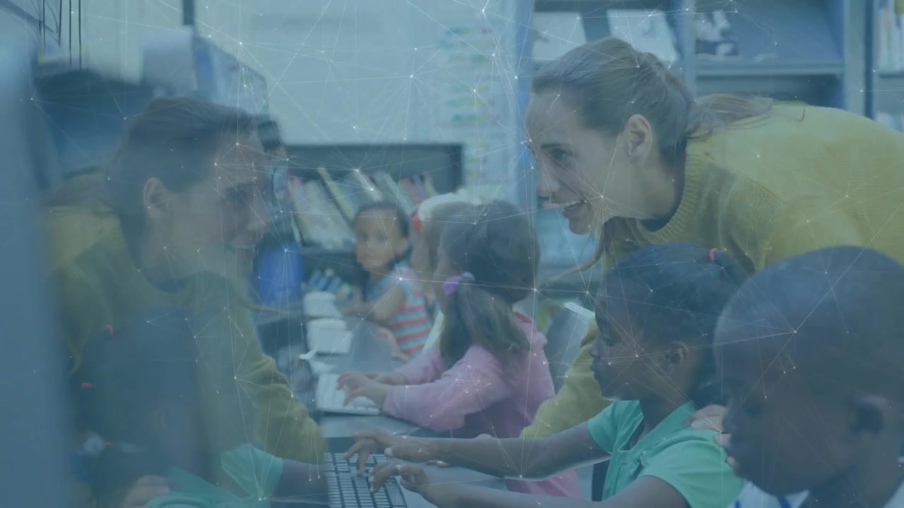 Un insegnante entra nel laboratorio scolastico e si muove tra i banchi, guidando gli studenti che digitano sulle tastiere per l'apprendimento.