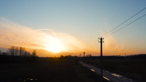 Moody-aerial-view-during-golden-hour-with-electric-power-line-near-gravel-road