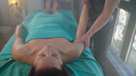 mujer recibiendo un masaje en el hombro