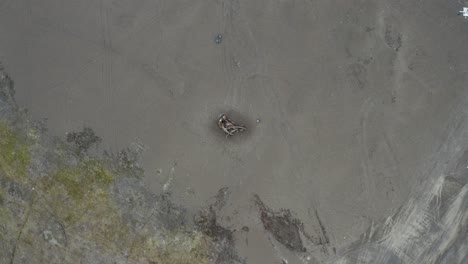 Aerial-Top-Down-drone-Shot-of-Man-and-Whale-Carcass-on-Black-Sand-Beach-at-the-Northernmost-Point-of-the-Arctic-United-States-near-Barrow-Alaska