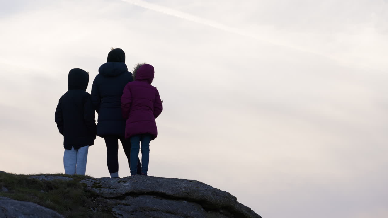 Family on a hilltop at sunset