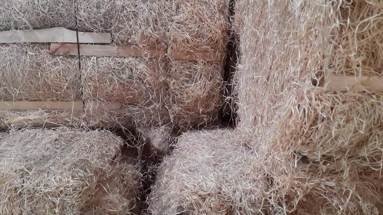 panning video of wood wool grass stock in cooler wood wool pad manufacturer's godown in India for the stock is for the summer season