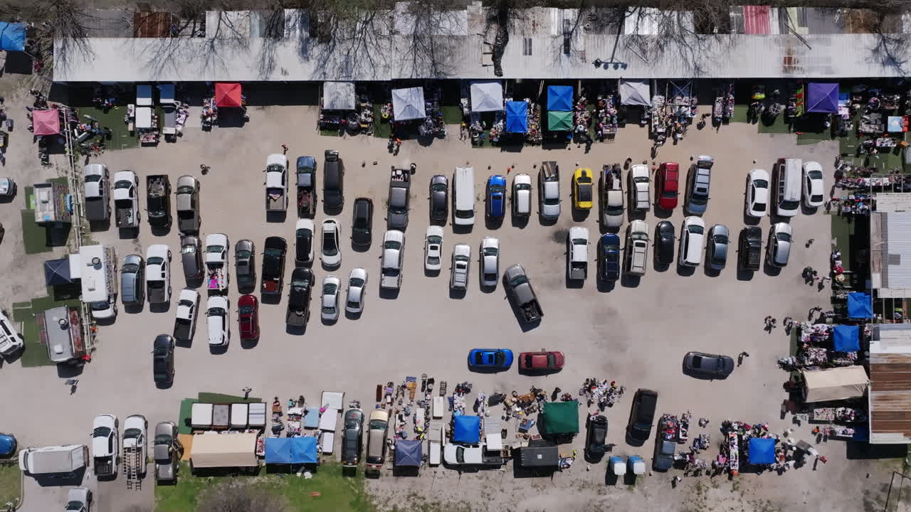 imágenes aéreas de autos en un estacionamiento del mercado de pulgas en houston, texas.