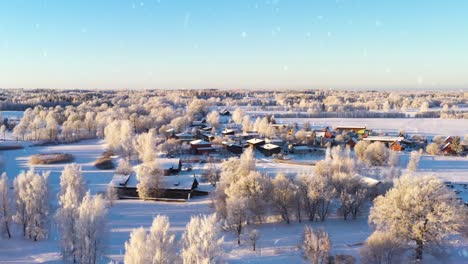 Magische-Wintergemeinde-Und-Natürliche-Umgebung-Bei-Schneefall,-Luftaufnahme