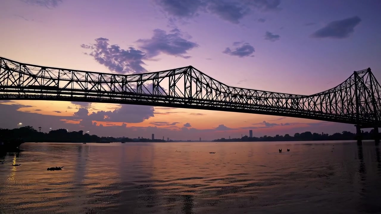 Silhuet af Howrah Bridge over Hooghly-floden ved solnedgang