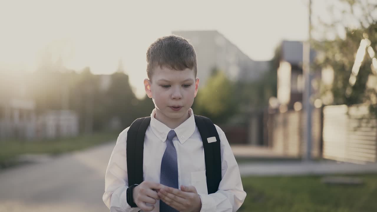 학교 유니폼을 입고 등 뒤에 배 ⁇ 을 들고 손가락으로 세는 학교 소년의 트래킹 초상화
