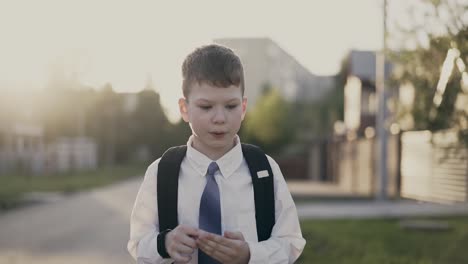 cu tracking portrait of schoolboy with knapsack behind his back in school uniform he counts on his fingers