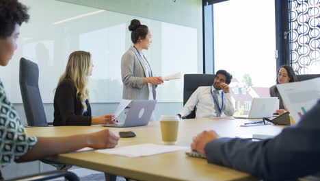 Geschäftsfrau-Leitet-Ein-Multikulturelles-Geschäftsteam,-Das-Sich-Am-Tisch-Im-Büro-Trifft-Und-Zusammenarbeitet