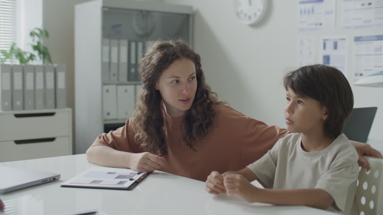Female Doctor in Hijab Talking to Woman and Her Young Son at Pediatric Office