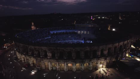 Slow-dolly-toward-the-Stromae-concert-with-bright-vibrant-lights-in-the-Nimes-Arena