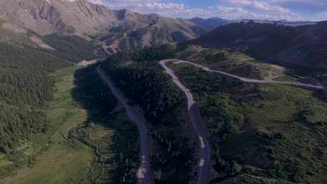 Cars-driving-around-high-elevation-winding-rocky-mountain-pass-drone-4k