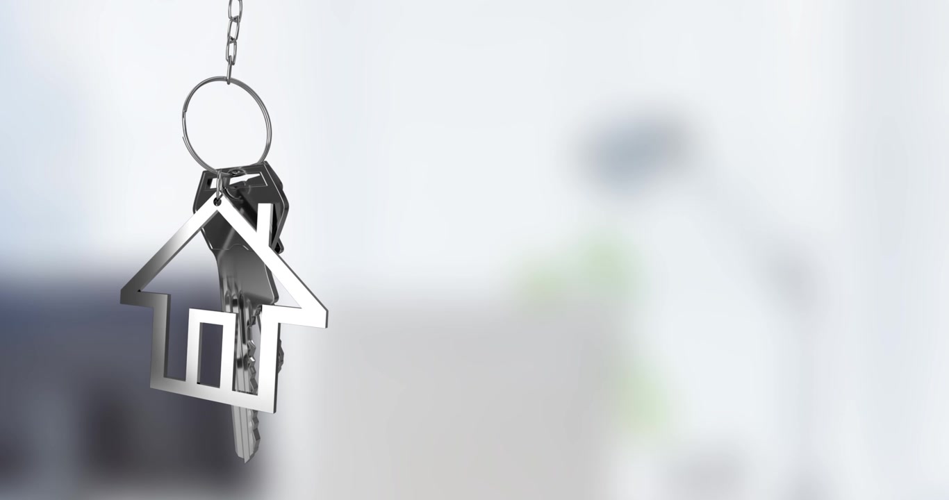 Portachiavi a forma di casa con chiavi appese su sfondo sfocato