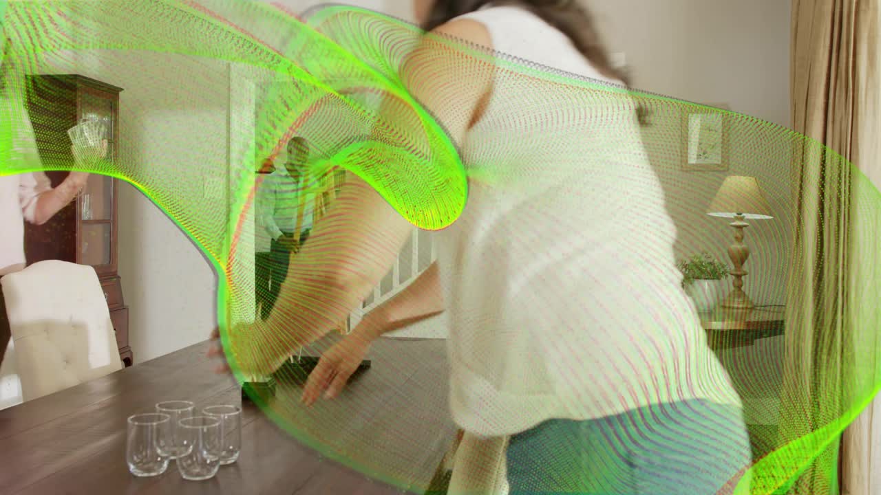 Woman entering doorway, arranging glasses on table for meal, green wave overlay for interior design