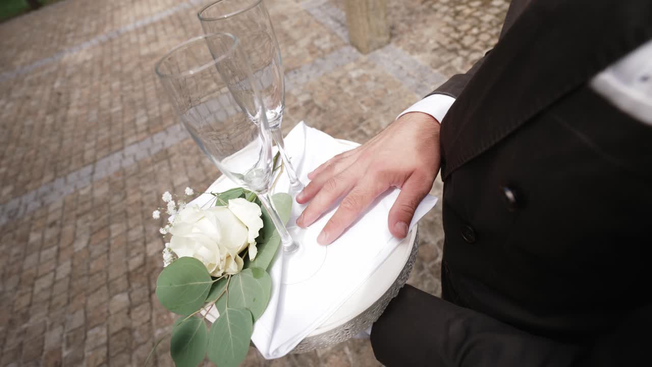 Sophisticated hold of bubbly glasses and white blooms evoking celebratory romance