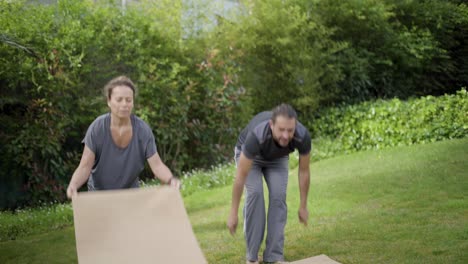 people holding yoga mats in park