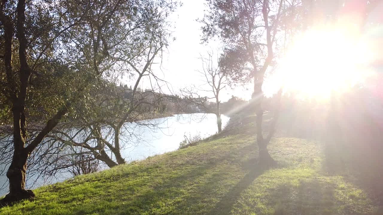 Winter Riverside flying. Sunset drone above the Arno river. Girone small town near Fiesole Florence, in the Tuscany region of Italy. December 2019