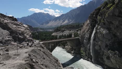 aerial view of ganesh bridge and waterfall in hunza valley, pakistan, drone shot