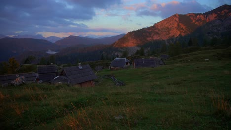 movimiento con un cardán de metraje en las montañas eslovenas en los alpes en un increíble amanecer en hermosos colores con una cámara que avanza lentamente en un pequeño pueblo de madera de montaña