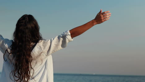 mujer feliz con los brazos extendidos en la playa