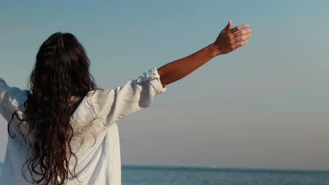 happy woman with arms outstretched at the beach