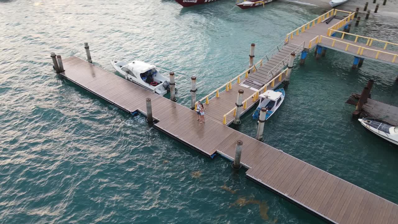 dulce pareja abrazándose en el muelle en el puerto de gili air island durante las vacaciones