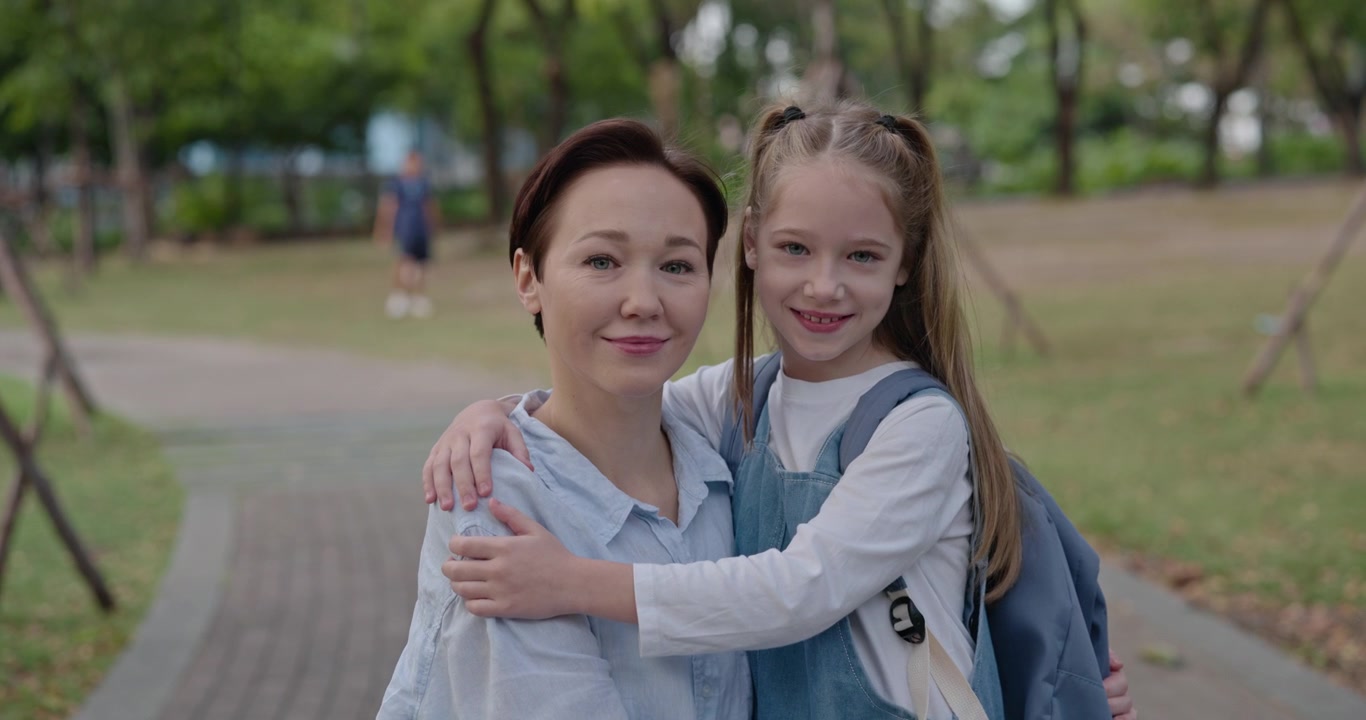 公園で抱き合って微笑む笑顔の母娘
