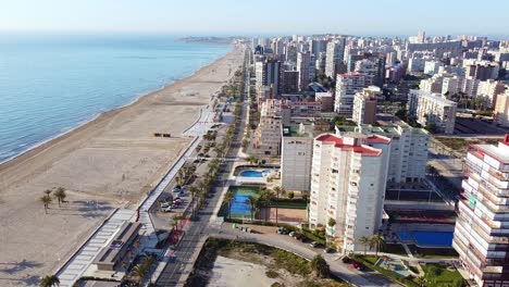 Aerial-drone-footage-of-high-buildings-with-swimming-pools-near-the-sea-and-beach-of-San-Juan,-Spain