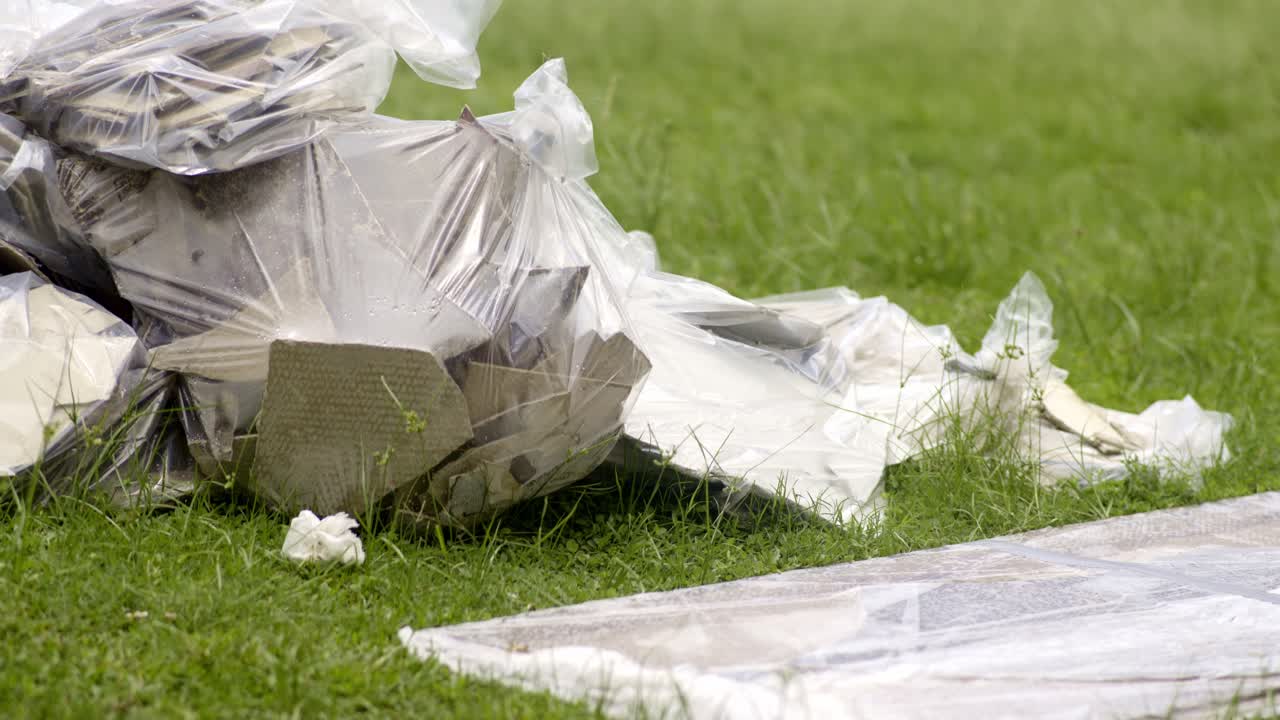 Pile of construction debris and garbage bags on the grass