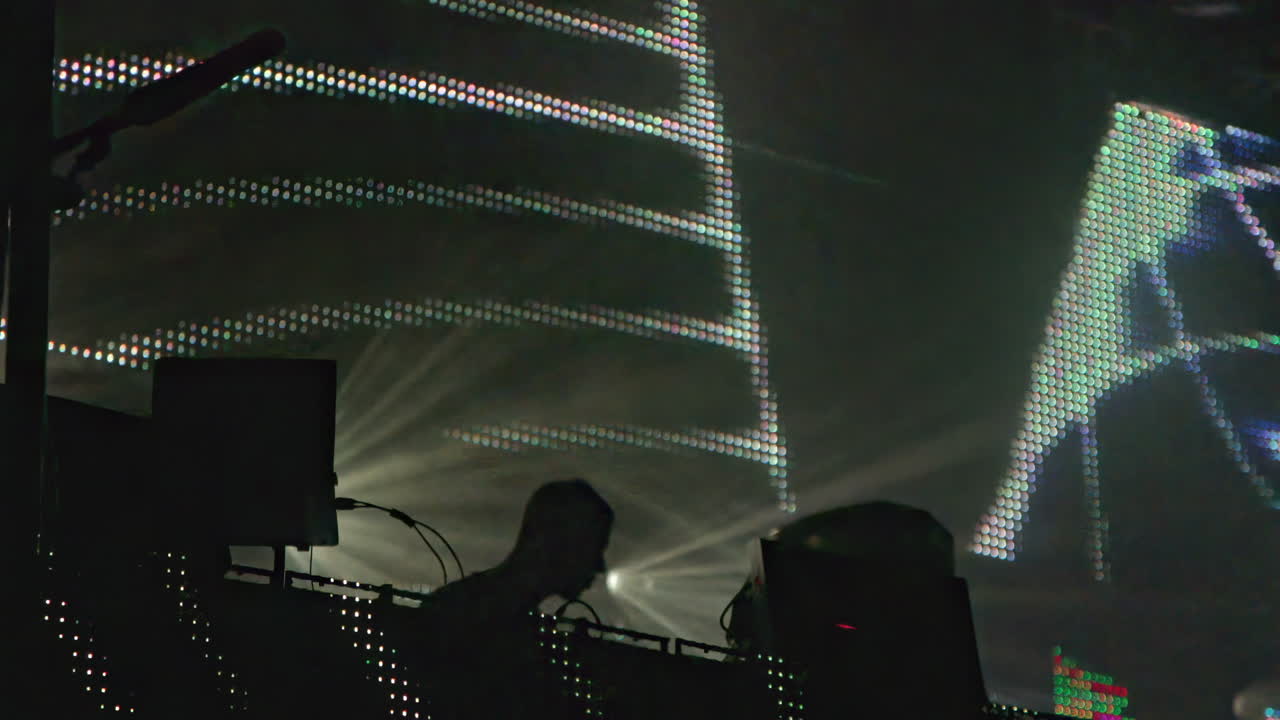 DJ performing on stage with lights