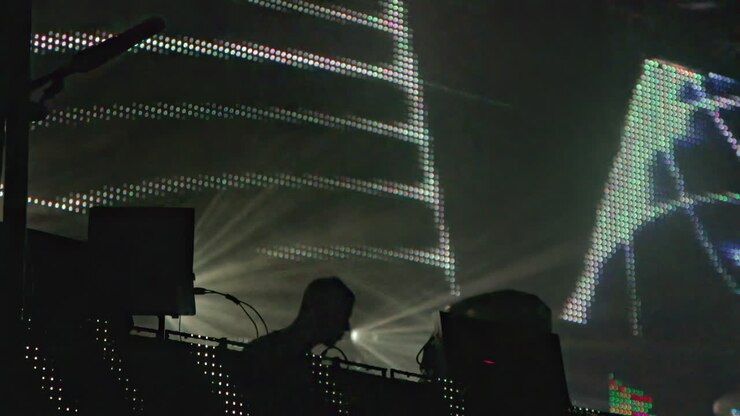 DJ che si esibisce sul palco con le luci