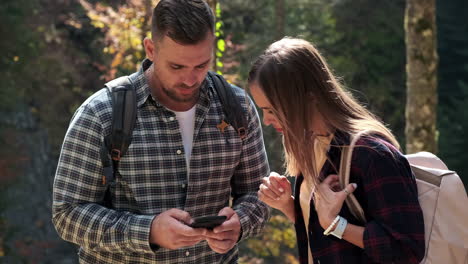 couple using phone while hiking in the forest