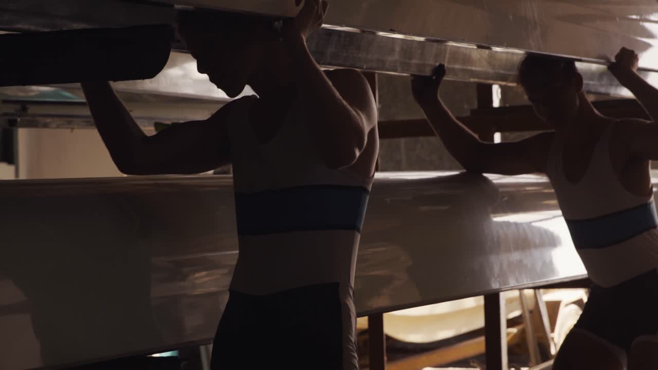 남자 로워 팀 이 머리 위 에 보트 를 들고 움직이고 있다