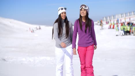 Two-attractive-young-woman-walking-in-fresh-snow