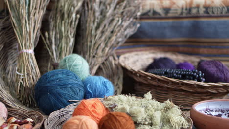 medium closeup pans across balls of yarns with natural fibers and goods in woven bowls