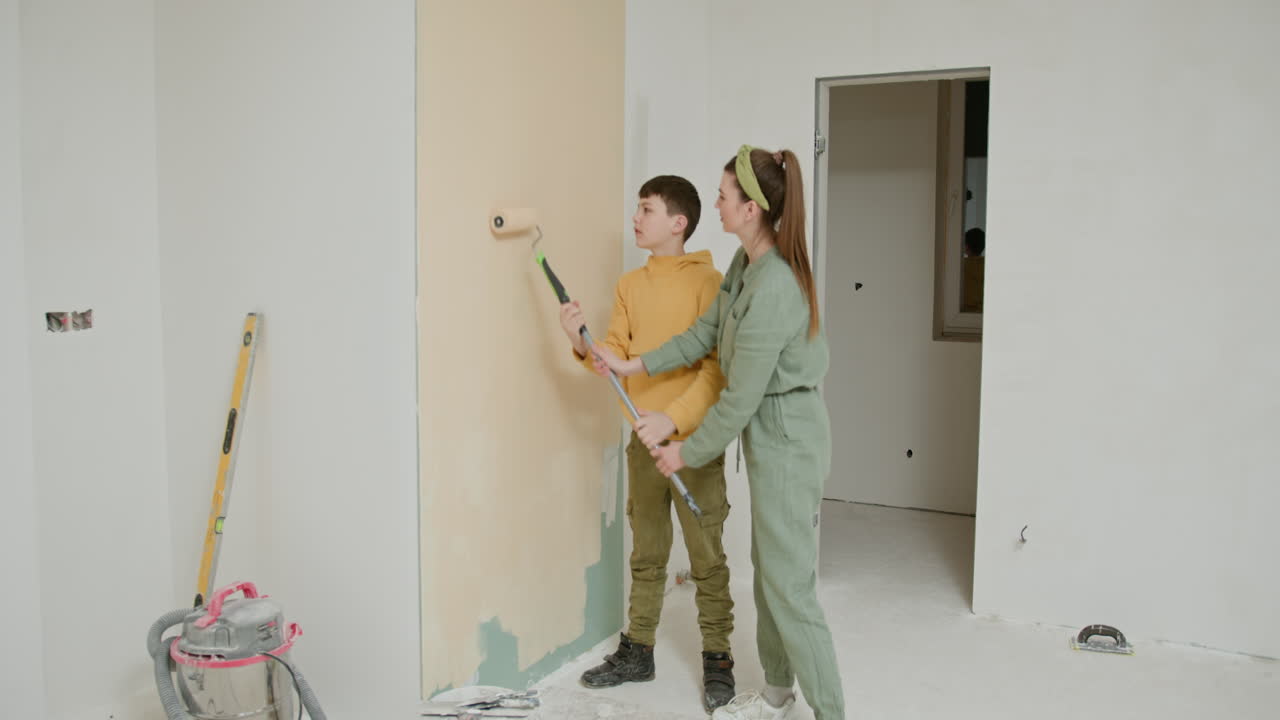madre y hijo pintando una pared juntos