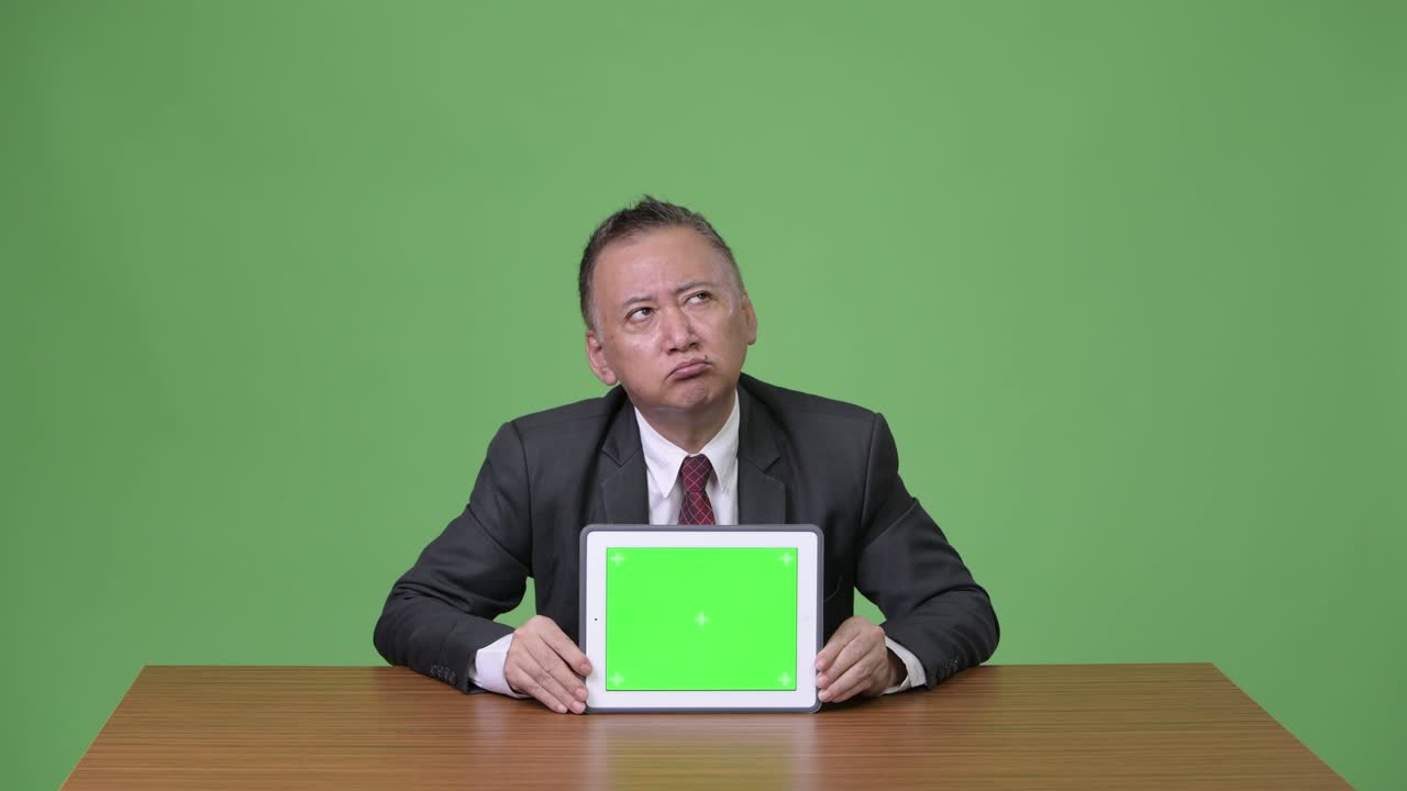 디지털 태블릿을 보여주는 성숙한 일본 사업가