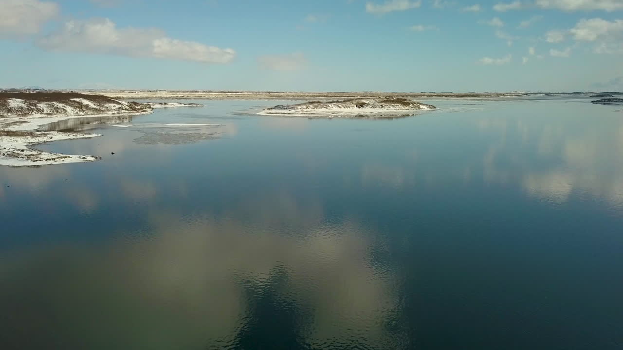кинематографическая съемка с воздуха над рекой олфуса в районе селфосс исландия с отражением неба на воде