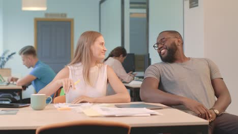 young man rolling up to lady sitting on chair. black man flirting with woman