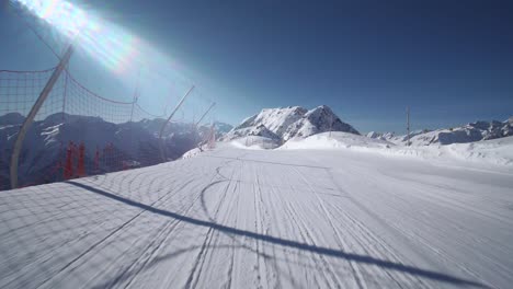 first person view pov: skier skiing with amazing mountain scenery in swiss alps on perfect slopes