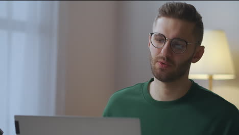joven especialista está discutiendo preguntas de trabajo con colegas durante una reunión en línea hablando con la cámara web de una computadora portátil en la oficina de casa