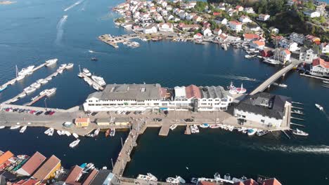 aerial: sea side hill island city with port at kragero, norway - drone tilt up shot