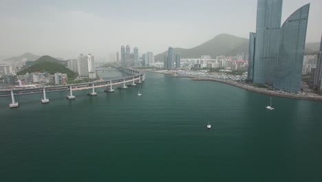 Aerial-shot-of-giant-Gwangandeagyo-Bridge-in-Busan-with-skyscrapers-in-South-Korea