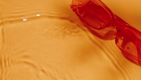 red sunglasses on water