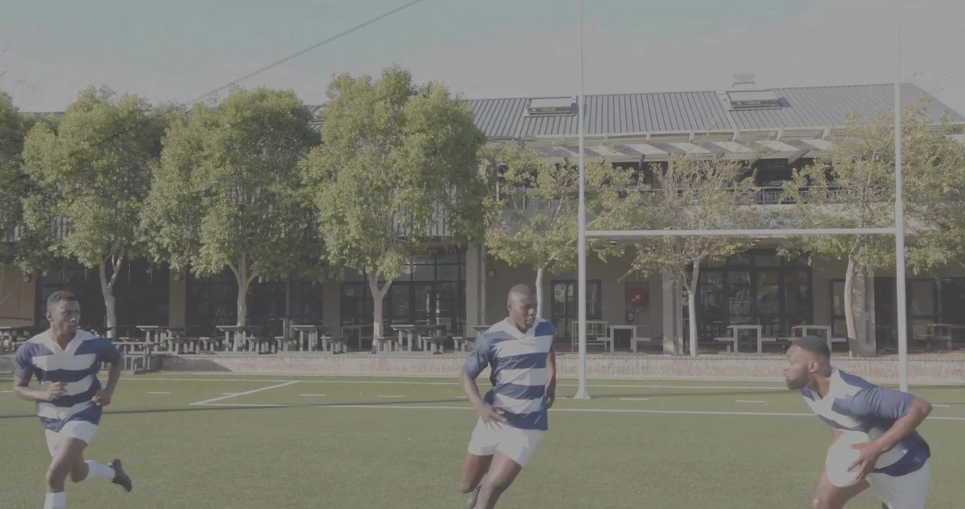 Vertikal video: Rugbytrio løber på græstæppe, center starter løb og afleverer bolden til højre for mål.