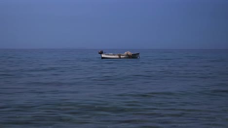 Friedliche-Szene-Mit-Dem-Ruhigen-Meer-Als-Ruhigem-Hintergrund,-Die-Die-Ruhe-Auf-Dem-Wasser-Und-Ein-Isoliertes-Fischerboot-Einfängt