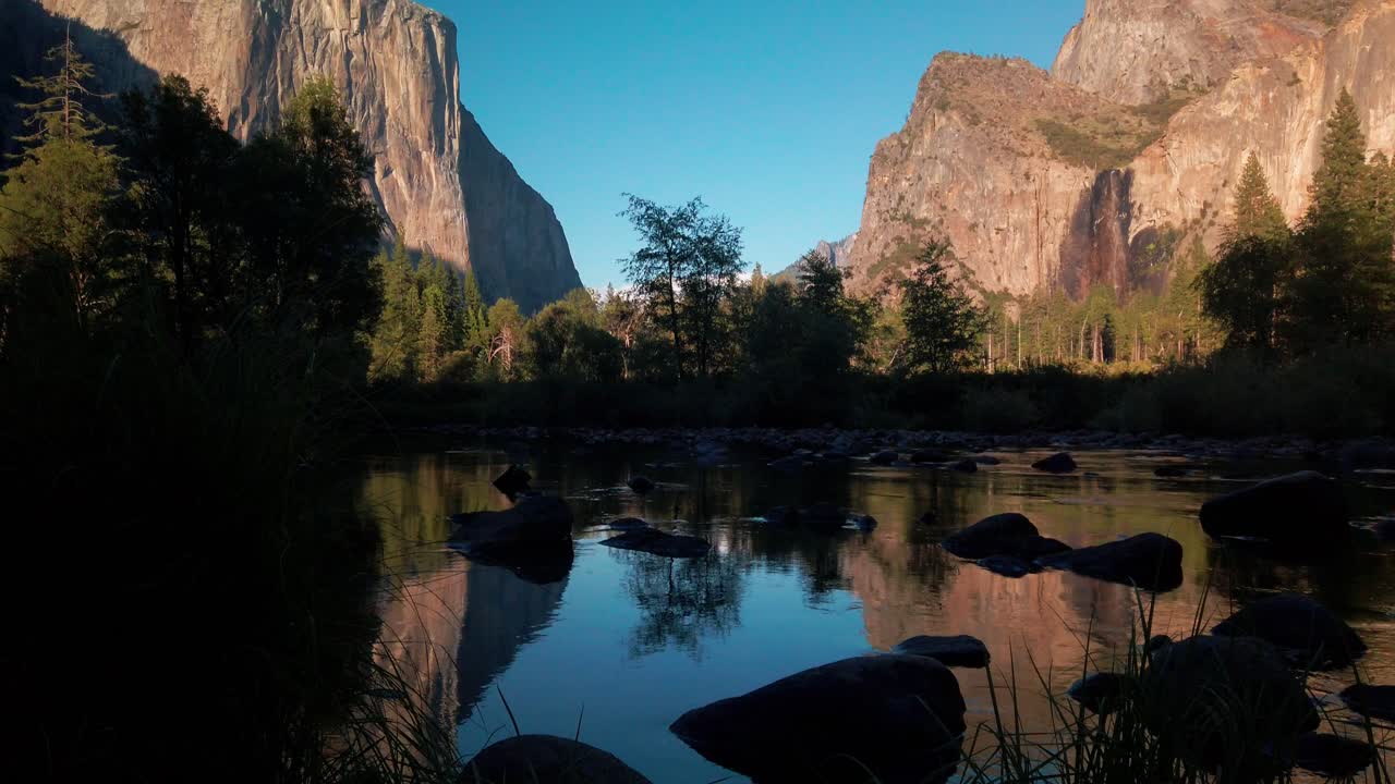 tiro inclinado desde un río de espejos reflectantes hasta imponentes picos de granito