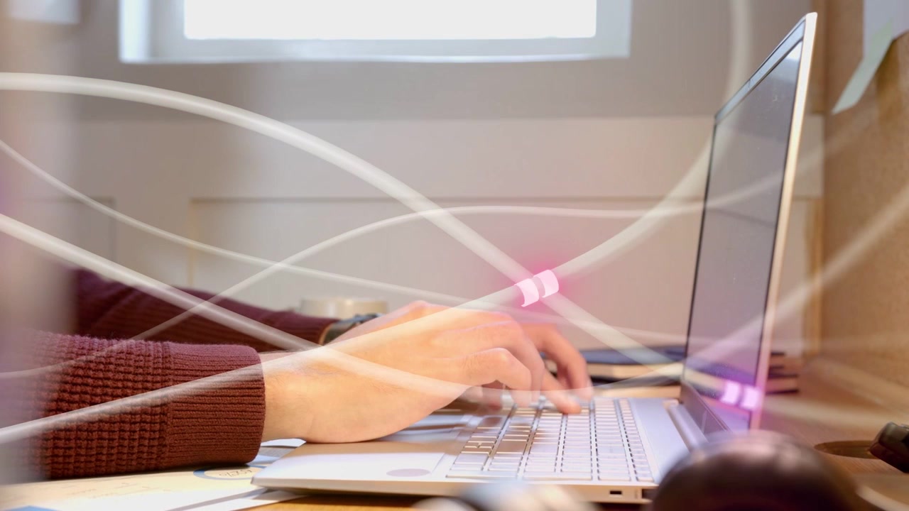 Uomo che inizia a digitare mentre le mani si muovono, programmando mentre scie di LED viola attraversano mani e tastiera
